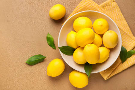 Plate with ripe lemons on color backgroundの写真素材