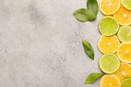 Ripe sliced lemons and limes on light backgroundの写真素材