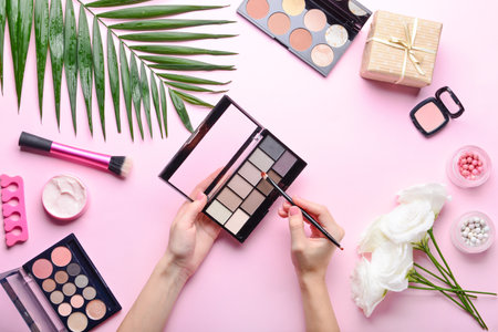 Female hands with makeup cosmetics on color background, top viewの写真素材