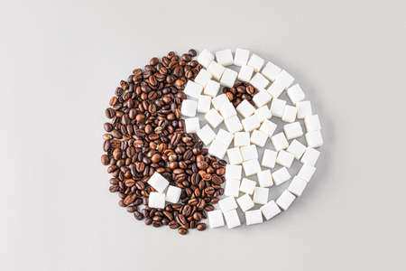 Yin-yang symbol made of coffee beans and sugar on light backgroundの写真素材