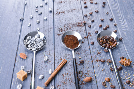 Creative composition with spoons and coffee beans on wooden tableの写真素材