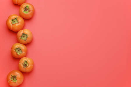 Ripe persimmons on color background