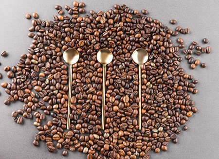 Spoons and coffee beans on gray backgroundの写真素材