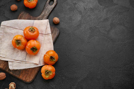 Ripe persimmons on dark backgroundの写真素材