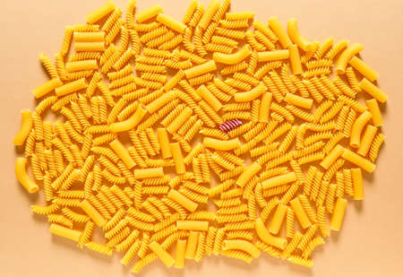 One pink pasta among others. Difference and uniqueness concept