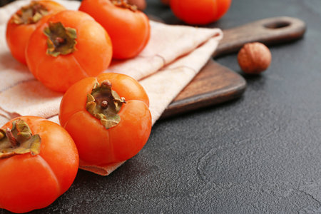 Ripe persimmons on dark backgroundの写真素材