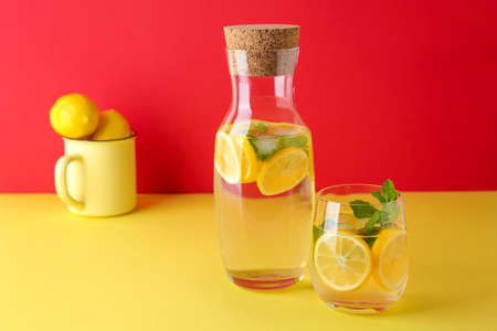 Bottle and glass of fresh lemonade on tableの写真素材