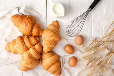 Tasty croissants with ingredients on tableの写真素材