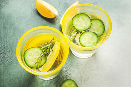 Glasses of cold cucumber water on color backgroundの写真素材