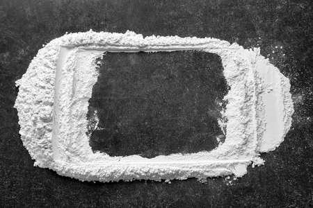 Frame made of flour on dark background