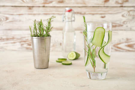 Glass of cold cucumber water on light tableの写真素材