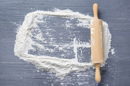 Rolling pin and frame made of flour on wooden backgroundの写真素材