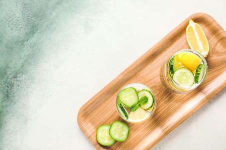 Glasses of cold cucumber water on light backgroundの写真素材