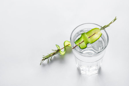 Glass of cold cucumber water on light backgroundの写真素材