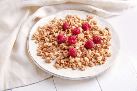 Plate with tasty granola on table