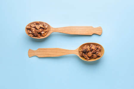 Spoons with tasty granola on color backgroundの写真素材