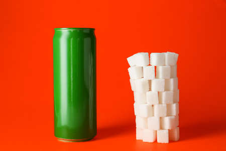 Can of soda and stacked sugar cubes on color backgroundの写真素材