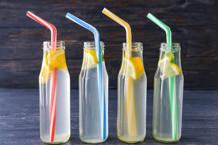 Bottles of fresh lemonade on dark wooden backgroundの写真素材