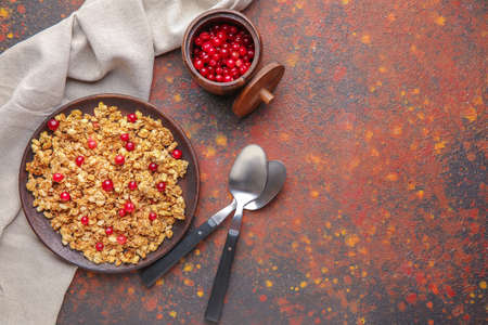 Plate with tasty granola and berries on color background