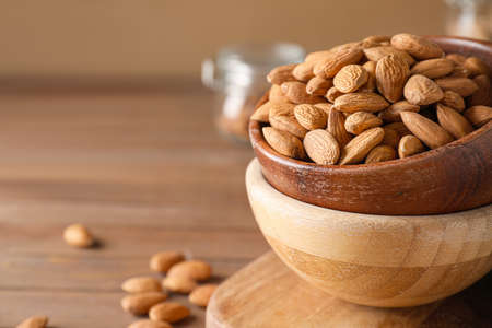 Bowls with tasty almonds on wooden table, closeupの写真素材