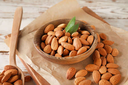 Plate with tasty almonds on wooden tableの写真素材