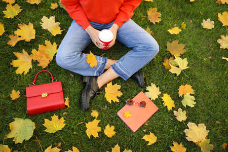 Beautiful young woman resting in autumn parkの写真素材
