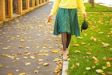 Beautiful young woman walking in autumn city