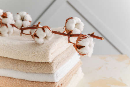 Soft clean towels with cotton flowers on tableの写真素材