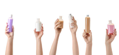 Female hands with different cosmetic products in bottles on white background