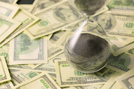 Hourglass on dollar banknotesの写真素材