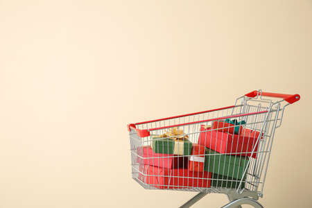 Shopping cart with gifts near color wall