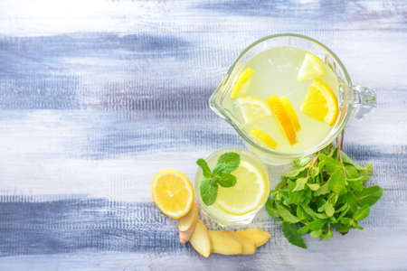 Glass and jug of tasty lemonade on wooden backgroundの写真素材