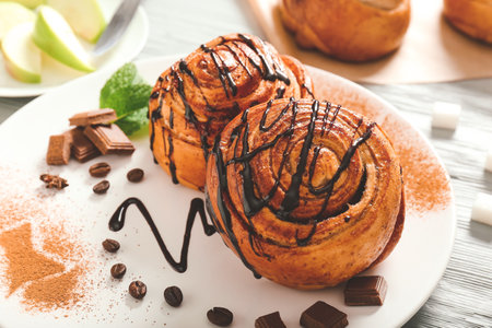 Plate with tasty cinnamon buns on tableの写真素材