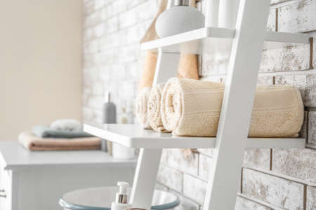 Rolled towels on shelf in bathroomの写真素材