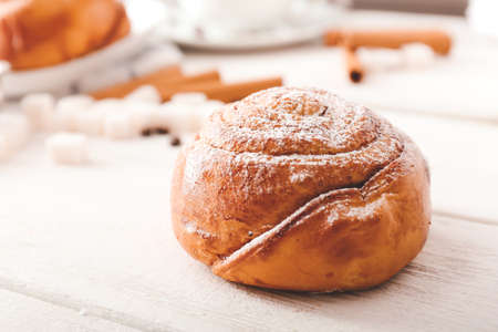 Tasty cinnamon bun on white tableの写真素材