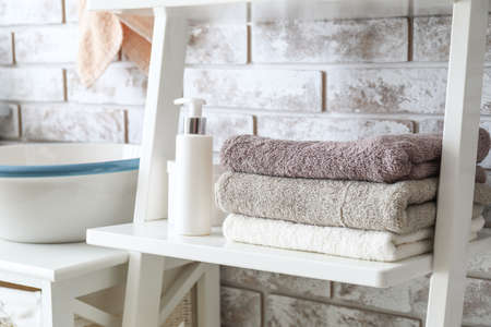 Stack of towels on shelf in bathroomの写真素材