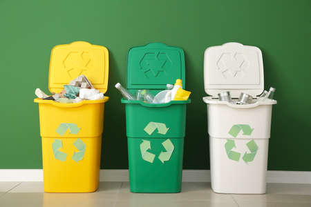 Containers with different types of garbage near color wall. Recycling conceptの写真素材