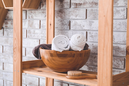 Bowl with clean towels on shelf in bathroomの写真素材