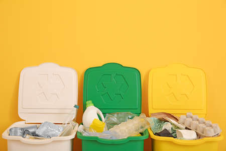 Containers with different types of garbage near color wall. Recycling conceptの写真素材