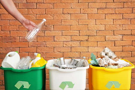 Man throwing garbage into container. Recycling concept