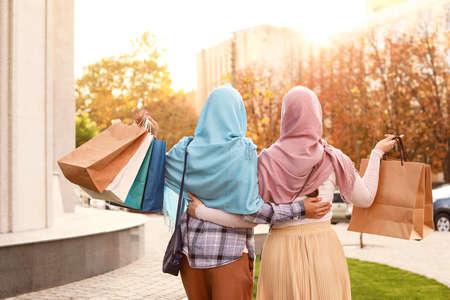 Beautiful Muslim women with shopping bags outdoorsの写真素材