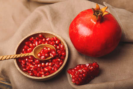 Ripe juicy pomegranate with seeds on fabric