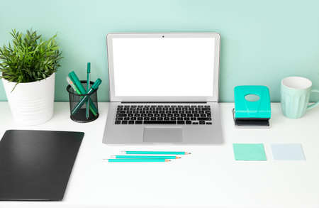 Comfortable workplace with modern laptop near color wallの写真素材