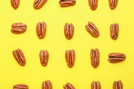 Tasty pecan nuts on color backgroundの写真素材
