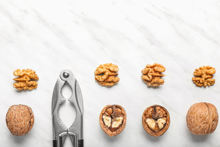 Nutcracker with tasty walnuts on white backgroundの写真素材