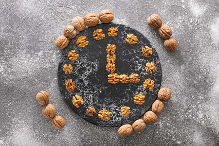 Composition with tasty walnuts and board on gray background