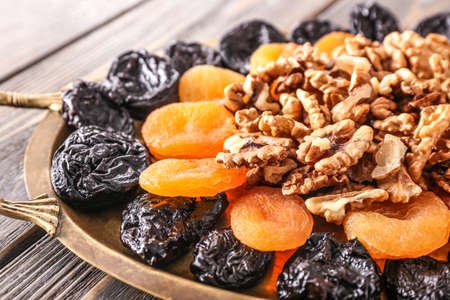 Tray with tasty walnuts and dried fruits on table, closeupの写真素材