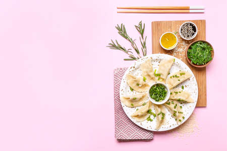 Plate with tasty Japanese gyoza and sauces on color backgroundの写真素材