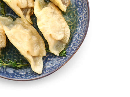 Plate with tasty Japanese gyoza on white background