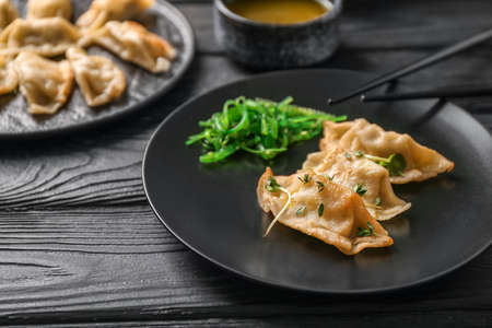 Plate with tasty Japanese gyoza on wooden tableの写真素材